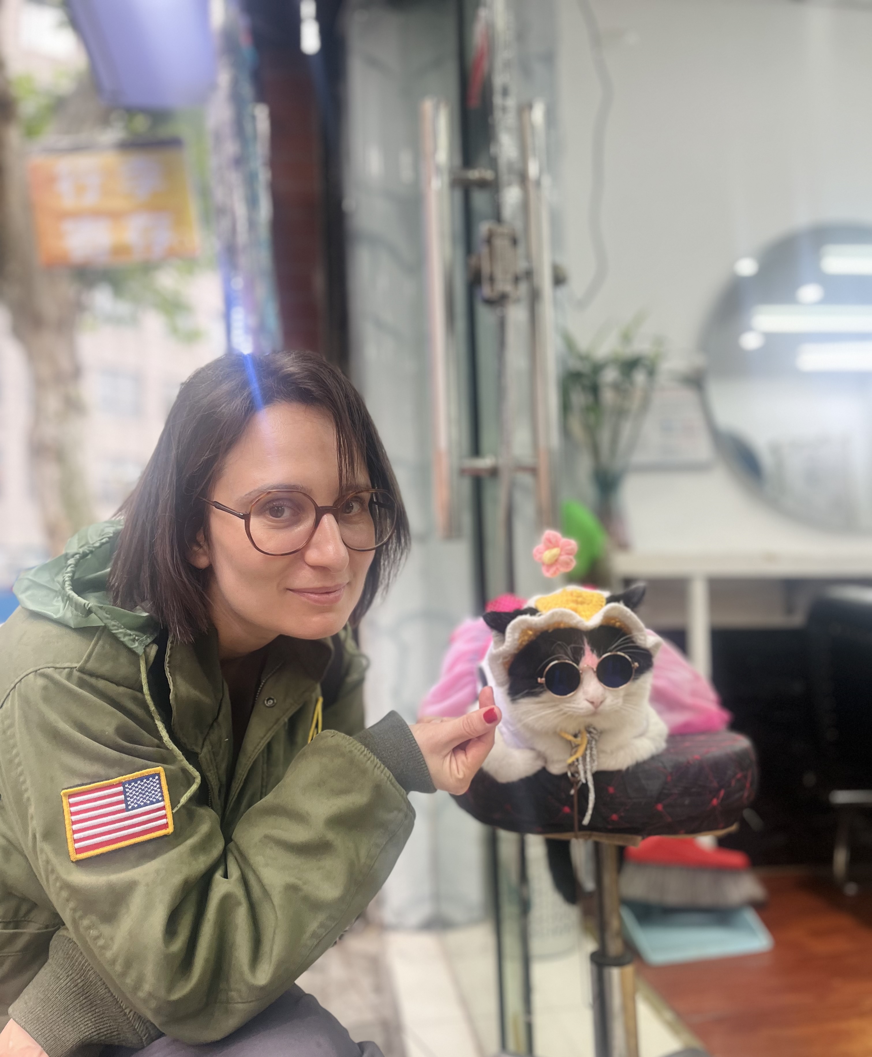 moi à Shnaghai avec un chat déguisé et probablement drogué, portant une veste de l'armée américaine avec un énorme drapeau US à l'épaule.